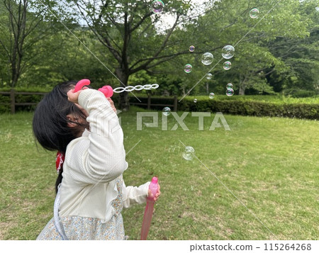 Girls blowing soap bubbles Girls blowing soap bubbles 115264268