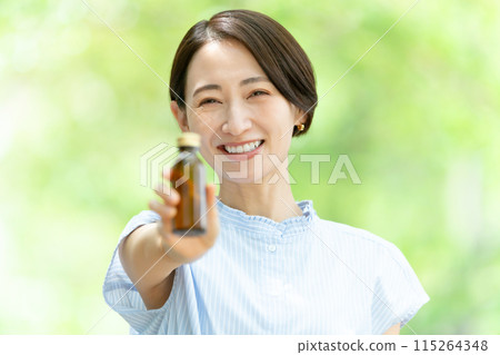 Woman drinking energy drink, fresh greenery 115264348