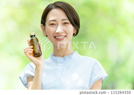 Woman drinking energy drink, fresh greenery Woman drinking energy drink, fresh greenery 115264350