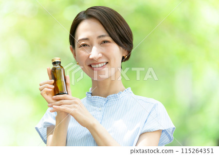 Woman drinking energy drink, fresh greenery Woman drinking energy drink, fresh greenery 115264351