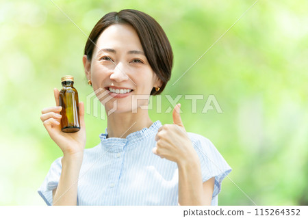 Woman drinking energy drink, fresh greenery 115264352