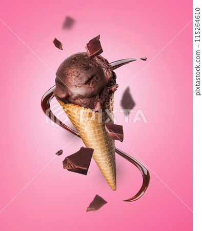 Composition levitation of chocolate ice cream waffle cone with pieces of chocolate on pink background. In the air, vertical Composition levitation of chocolate ice cream waffle cone with pieces of chocolate on pink background. In the air, vertical 115264610