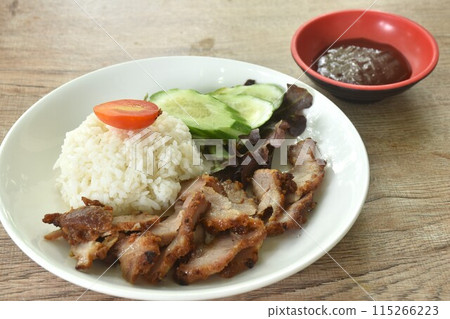 slice grilled fermenting porkwith milk topping rice eat couple cucumber and lettuce dipping spicy barbecue sauce on plate slice grilled fermenting porkwith milk topping rice eat couple cucumber and lettuce dipping spicy barbecue sauce on plate 115266223