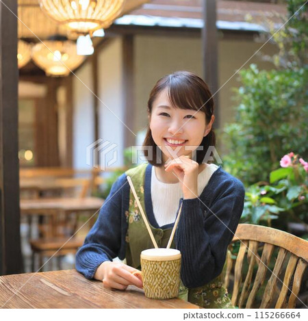 在咖啡館的一個少婦飲用的咖啡 在咖啡館的一個少婦飲用的咖啡 115266664