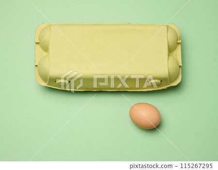 Chicken egg and paper storage box on green background, top view Chicken egg and paper storage box on green background, top view 115267295