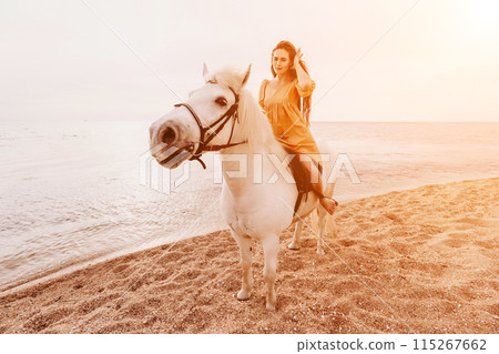 A woman in a dress stands next to a white horse on a beach, with the blue sky and sea in the background. A woman in a dress stands next to a white horse on a beach, with the blue sky and sea in the background. 115267662