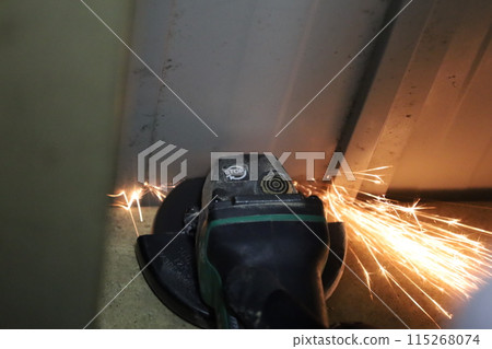 Cutting a steel plate with a sander Cutting a steel plate with a sander 115268074
