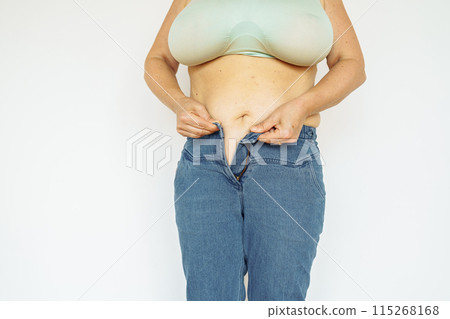 woman in jeans and top shows fat belly, saggy skin, excess weight 115268168