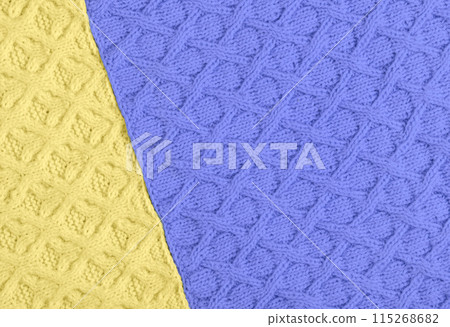 Knitted purple and yellow background. Large knitted fabric with a pattern. Close-up of a knitted blanket. Mockup for special offers as advertising or other ideas Knitted purple and yellow background. Large knitted fabric with a pattern. Close-up of a knitted blanket. Mockup for special offers as advertising or other ideas 115268682