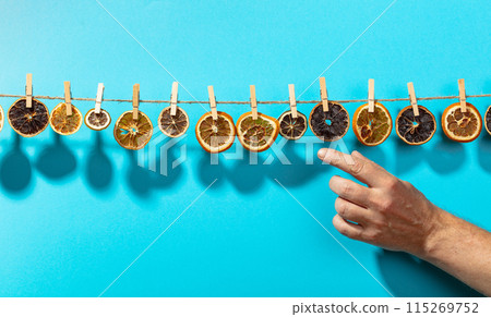 Orange, lemon and lime slices are dried on a line. Orange, lemon and lime slices are dried on a line. 115269752