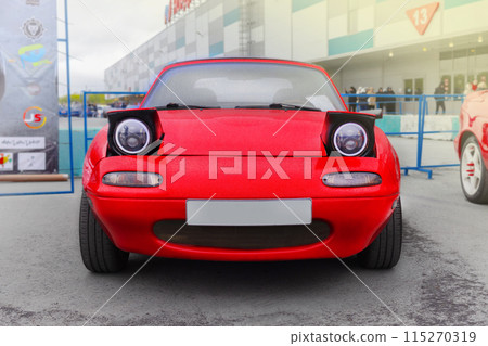 Russia, Novosibirsk, 25.05.2024 Midday, Red Mazda Miata MX-5 Roadster 1989, front view pop-up headlights close up Russia, Novosibirsk, 25.05.2024 Midday, Red Mazda Miata MX-5 Roadster 1989, front view pop-up headlights close up 115270319
