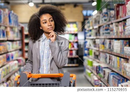 Woman browsing supermarket aisle, thoughtfully considering products. Shopper in casual attire, pushing cart in grocery store setting. Woman browsing supermarket aisle, thoughtfully considering products. Shopper in casual attire, pushing cart in grocery store setting. 115270935