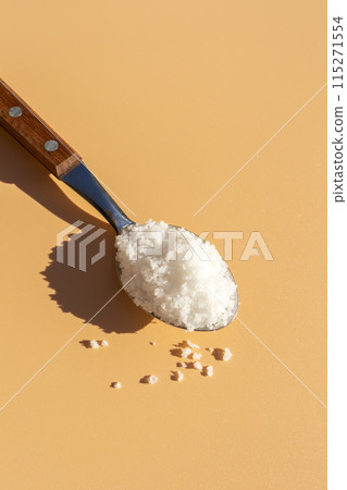 Top View Mockup Kosher Mineral Unrefined Sea Salt in Table Spoon, Natural Grain Crystals, Copy Space for Text. Beach Yellow Background. Baja Salt. Vertical Plane, Template 115271554