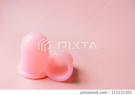 Pink silicone vacuum cups for anti-cellulite massage on a pink background Pink silicone vacuum cups for anti-cellulite massage on a pink background 115272301
