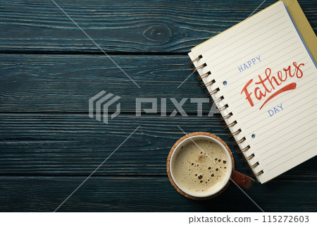 World father's day concept, with notebook on cup on blue background. World father's day concept, with notebook on cup on blue background. 115272603