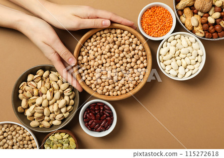 Set of protein products in bowls and hand on beige background, top view 115272618