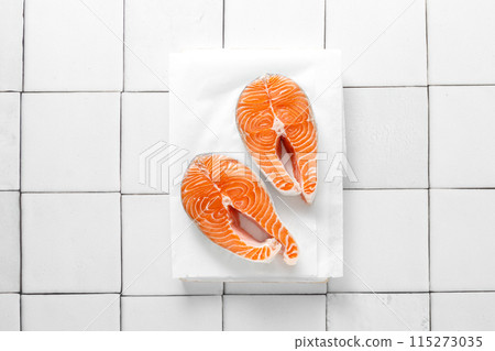 Fresh salmon steaks with herbs and ingredients for cooking, top view Fresh salmon steaks with herbs and ingredients for cooking, top view 115273035