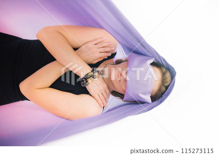 Woman lying in hammocks wearing lavender eye pillow for deep relaxation Woman lying in hammocks wearing lavender eye pillow for deep relaxation 115273115