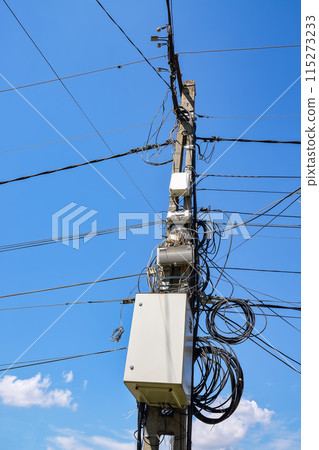 An image of messy electrical cables and wires on electric pole 115273233