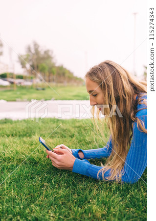 Fitness woman using mobilephone while exercising. Smiling woman doing stretching workout Fitness woman using mobilephone while exercising. Smiling woman doing stretching workout 115274343