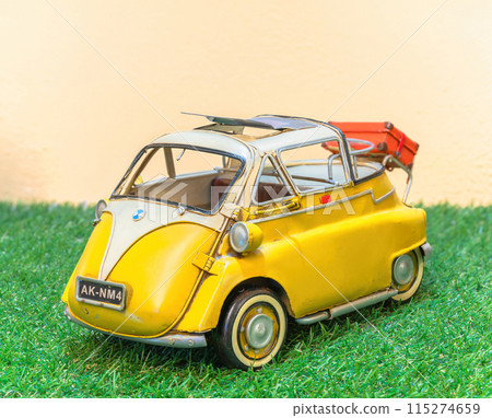[Material] Vintage toy replica depicting a retro car resembling a yellow BMW Isetta. 115274659
