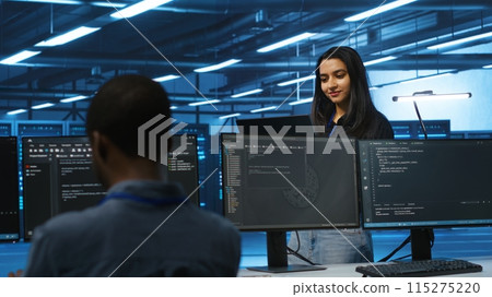 Cheerful supervisor in server room managing multiethnic team of technicians looking for equipment misconfigurations. Upbeat team leader coordinating workers fixing data center malfunctions 115275220