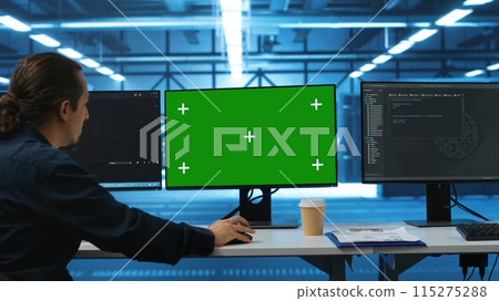 Software developer using green screen PC to do programming in server room providing computing resources for workloads. IT expert supervising data center supercomputers using mockup computer monitor Software developer using green screen PC to do programming in server room providing computing resources for workloads. IT expert supervising data center supercomputers using mockup computer monitor 115275288
