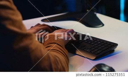 Computer scientist listening music while writing lines of code during remote job shift in home office. IT specialist enjoying audio podcast, coding on desktop PC, camera A extreme close up Computer scientist listening music while writing lines of code during remote job shift in home office. IT specialist enjoying audio podcast, coding on desktop PC, camera A extreme close up 115275351