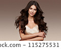Beautiful brown-haired girl with a perfectly curls hair, and classic make-up. Beauty face and hair. 115275531
