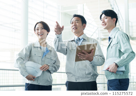 一名工人正在解釋工廠的情況 一名工人正在解釋工廠的情況 115275572