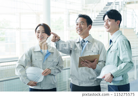 一名工人正在解釋工廠的情況 一名工人正在解釋工廠的情況 115275575