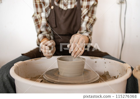 Young female potter using potter's wheel to shape ceramic bowl Young female potter using potter's wheel to shape ceramic bowl 115276368
