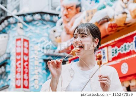 A young woman eating her way through Shinsekai, Osaka A young woman eating her way through Shinsekai, Osaka 115277859