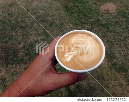 Holding a styrofoam cup of Cappuccino 115278852