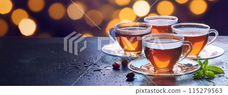 Several cups of tea on a table 115279563