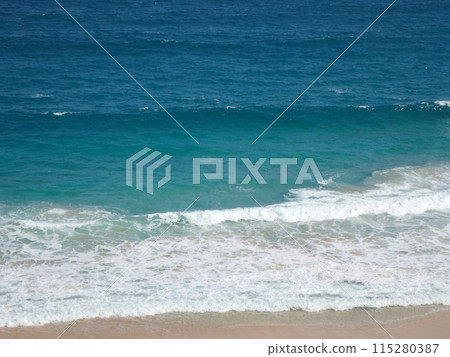 Waves crash on along beach 115280387