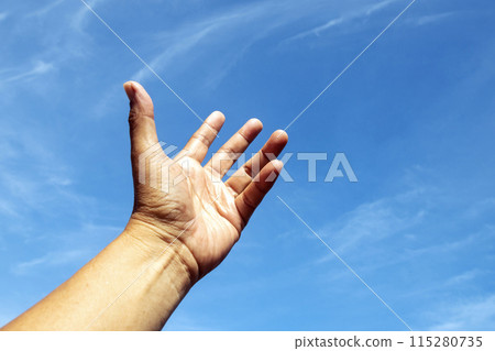 One left hand reaching up to the bright blue sky in hope. One left hand reaching up to the bright blue sky in hope. 115280735