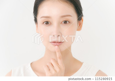 Photo of a woman pointing at her mouth Photo of a woman pointing at her mouth 115280915