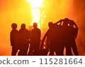 Extinguish the fire. A group of people were putting out a fire in the middle of the night 115281664