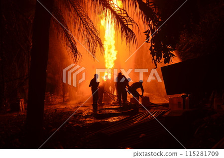 Extinguish the fire. A group of people were putting out a fire in the middle of the night. 115281709