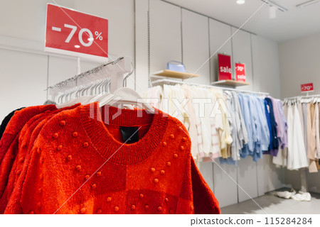 Clothes on hangers on display in a clothing store on sale 115284284