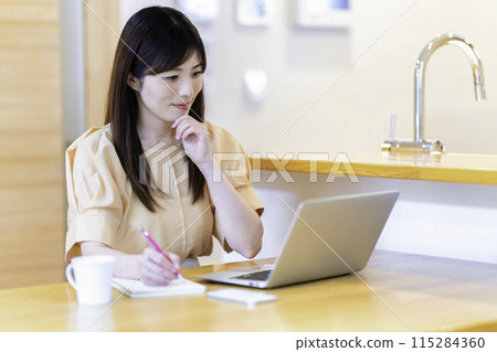 在餐桌上學習的女人 115284360
