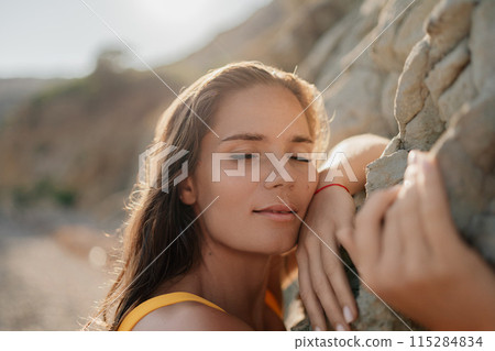 A woman is laying on a rock and looking at the camera 115284834