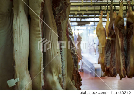 Pork meat in production. Fresh pork carcasses in a meat factory warehouse 115285230