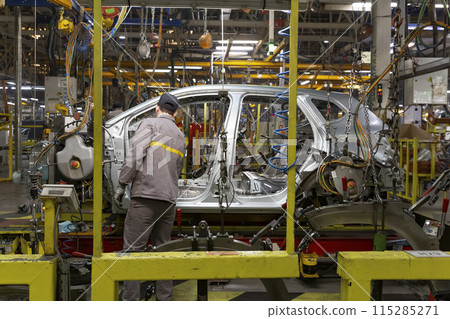Industrial production of car automobiles. Plant for assembling modern cars on an assembly line. Industry, production, industry concept. Industrial production of car automobiles. Plant for assembling modern cars on an assembly line. Industry, production, industry concept. 115285271