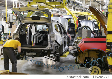 Industrial production of car automobiles. Plant for assembling modern cars on an assembly line. Industry, production, industry concept. Industrial production of car automobiles. Plant for assembling modern cars on an assembly line. Industry, production, industry concept. 115285272