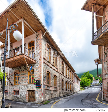 Traditional stone bricks building with a wooden balcony, located on a narrow street in Sheki, Azerbaijan Traditional stone bricks building with a wooden balcony, located on a narrow street in Sheki, Azerbaijan 115285467