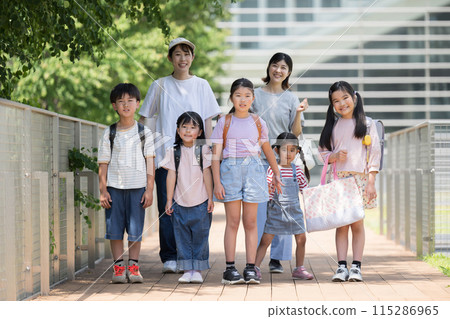 Elementary school students and their parents standing at school, morning school group, looking at camera 115286965