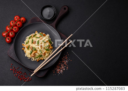 Delicious Asian cuisine dish with rice noodles, peppers, mushrooms and spices Delicious Asian cuisine dish with rice noodles, peppers, mushrooms and spices 115287083