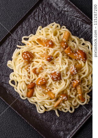 Delicious Asian cuisine dish with rice noodles, peppers, mushrooms and spices Delicious Asian cuisine dish with rice noodles, peppers, mushrooms and spices 115287200